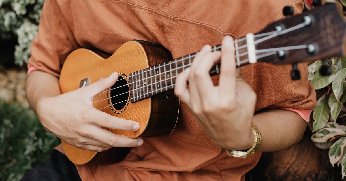 A close shot of someone playing a ukulele.