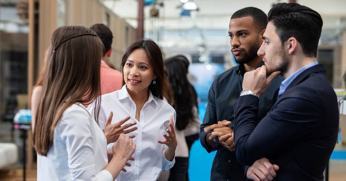 A group of people chatting and networking at a professional event.