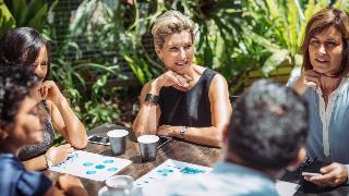 Two women sat at a table outside during a business meeting.