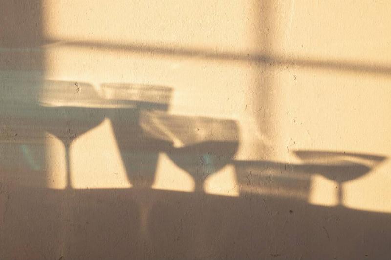 The shadows of multiple drink glasses that are all half-filled.