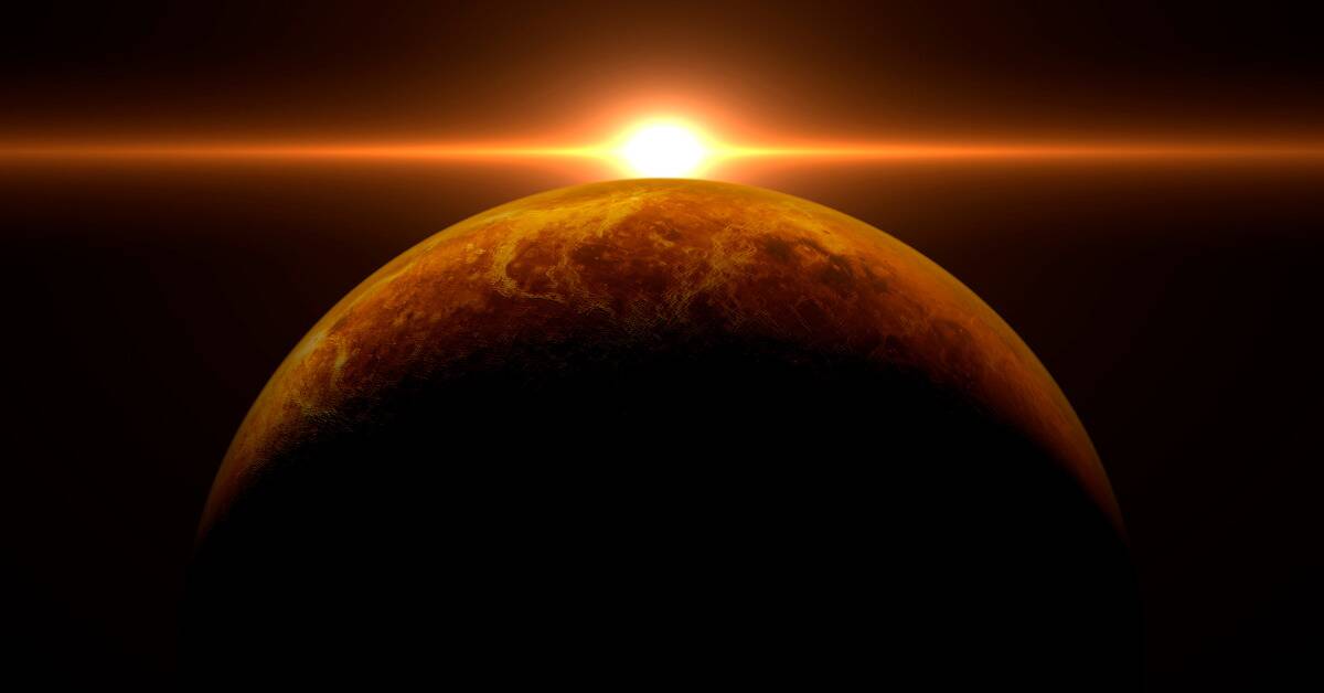 Venus in heavy shadow, the sun cresting over its horizon.