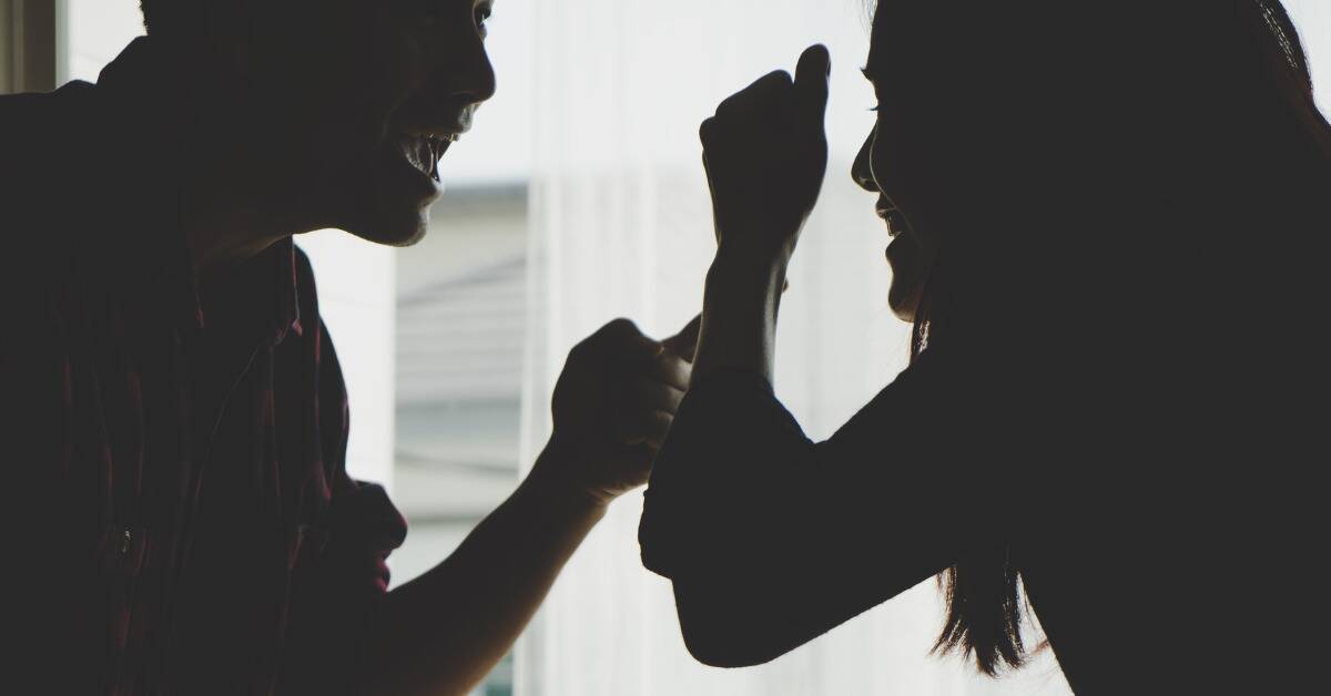 A silhouetted shot of a couple yelling at each other.