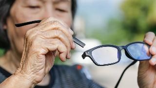 A person holding the arm that snapped off their glasses.