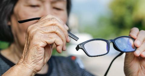 A person holding the arm that snapped off their glasses.