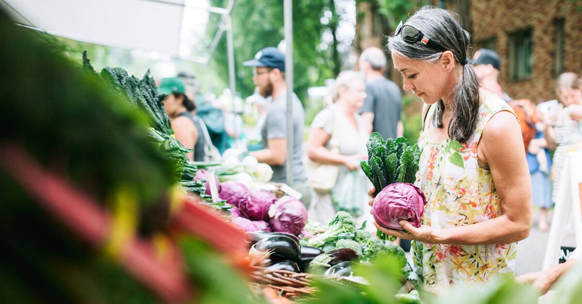 A woman shopping for veggies at a market.