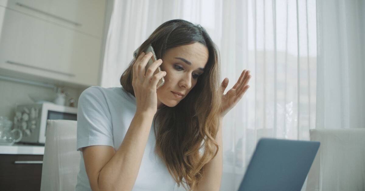 A woman visibly stressed as she talks to someone on the phone.