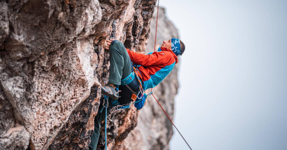 A man rock climbing a steep clifface.
