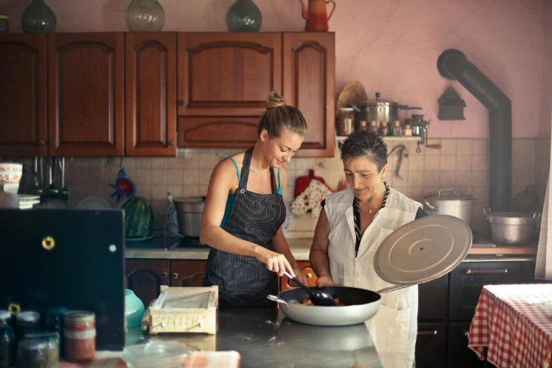 A mother and daughter cooking together in the kitchen.