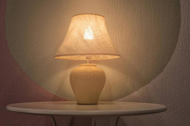 A small white lamp against a colorful wall.