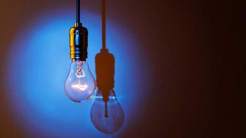A light bulb turned on, a blue spotlight being shined on it.