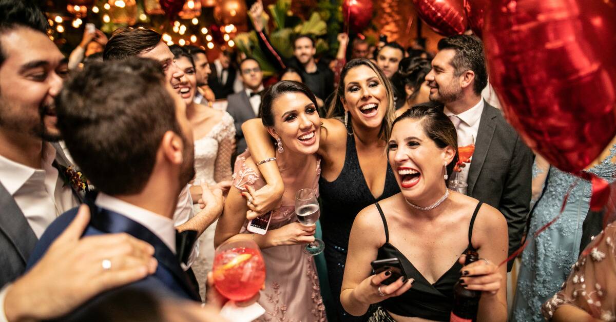 A group of people smiling and having fun in the midst of a busy party.
