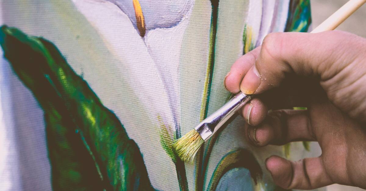 A close shot of someone painting the stem of a flower.