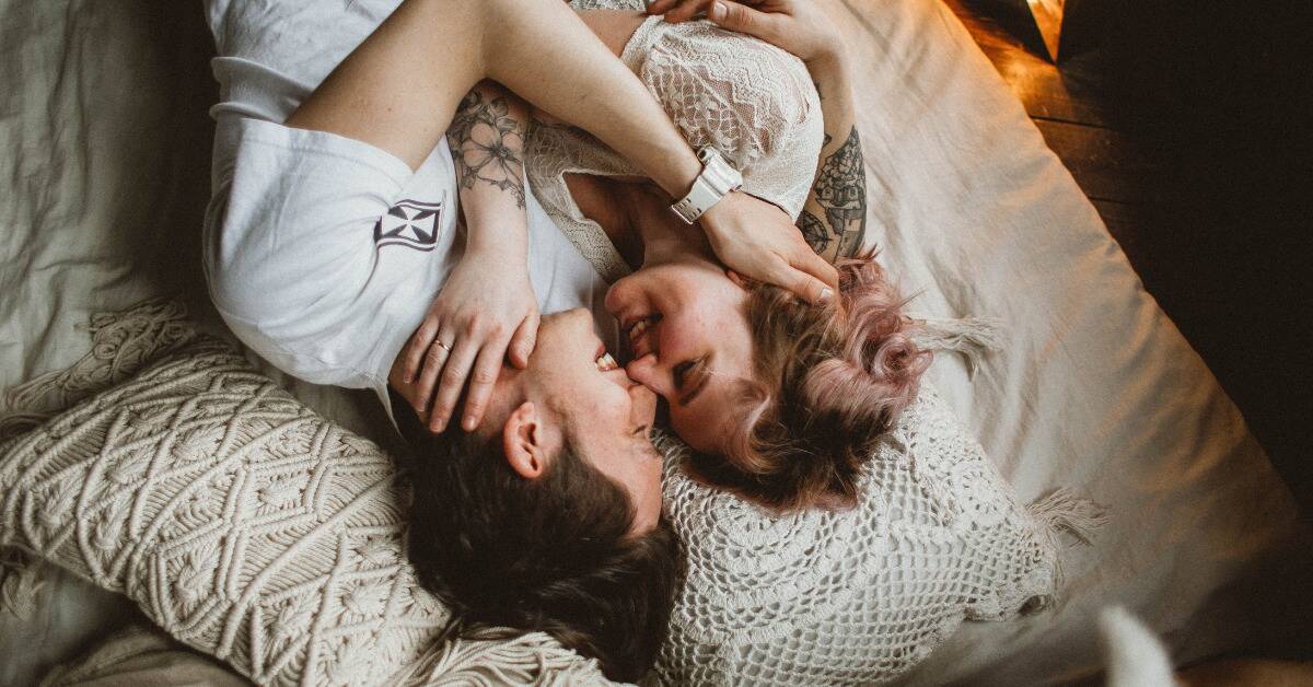 A couple in bed together, cuddling.