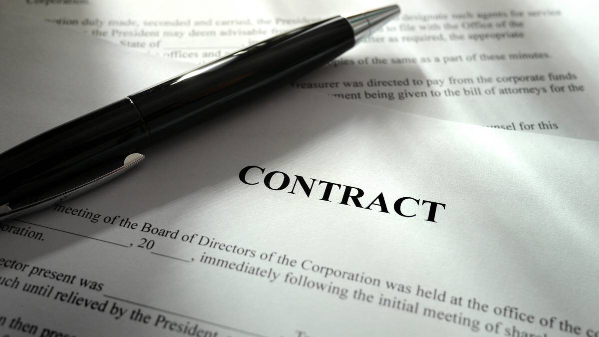 A close shot of a contract with a pend laid across it. 