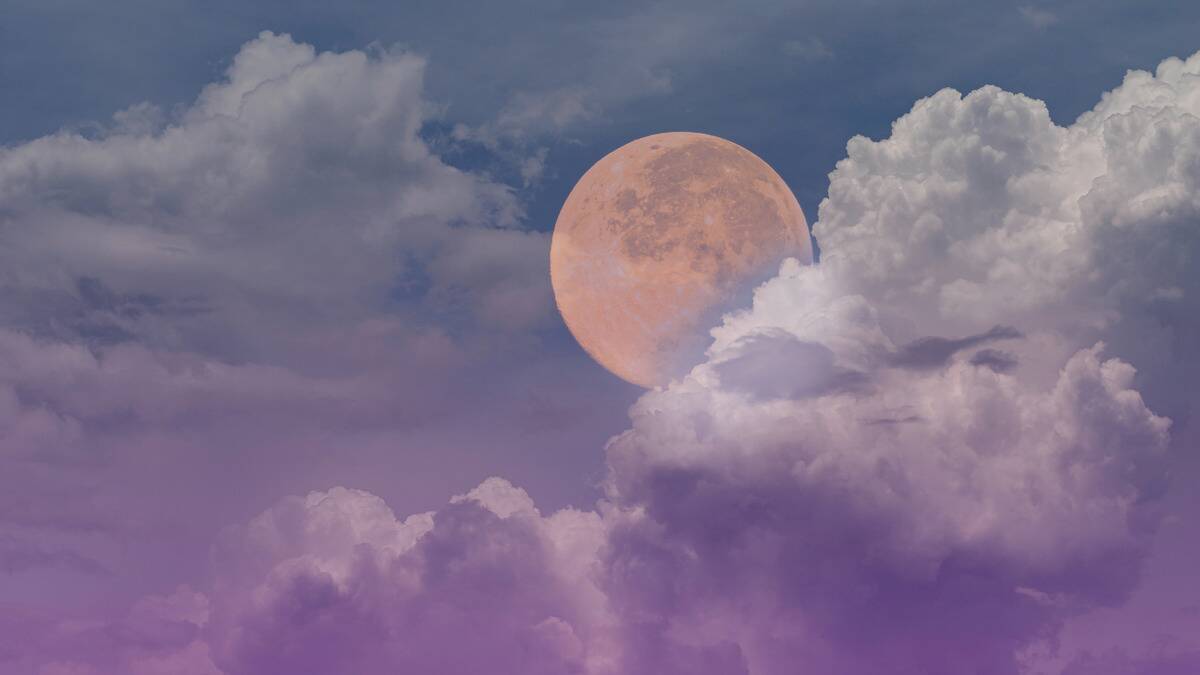 A colorful sky holding a light pink full moon.