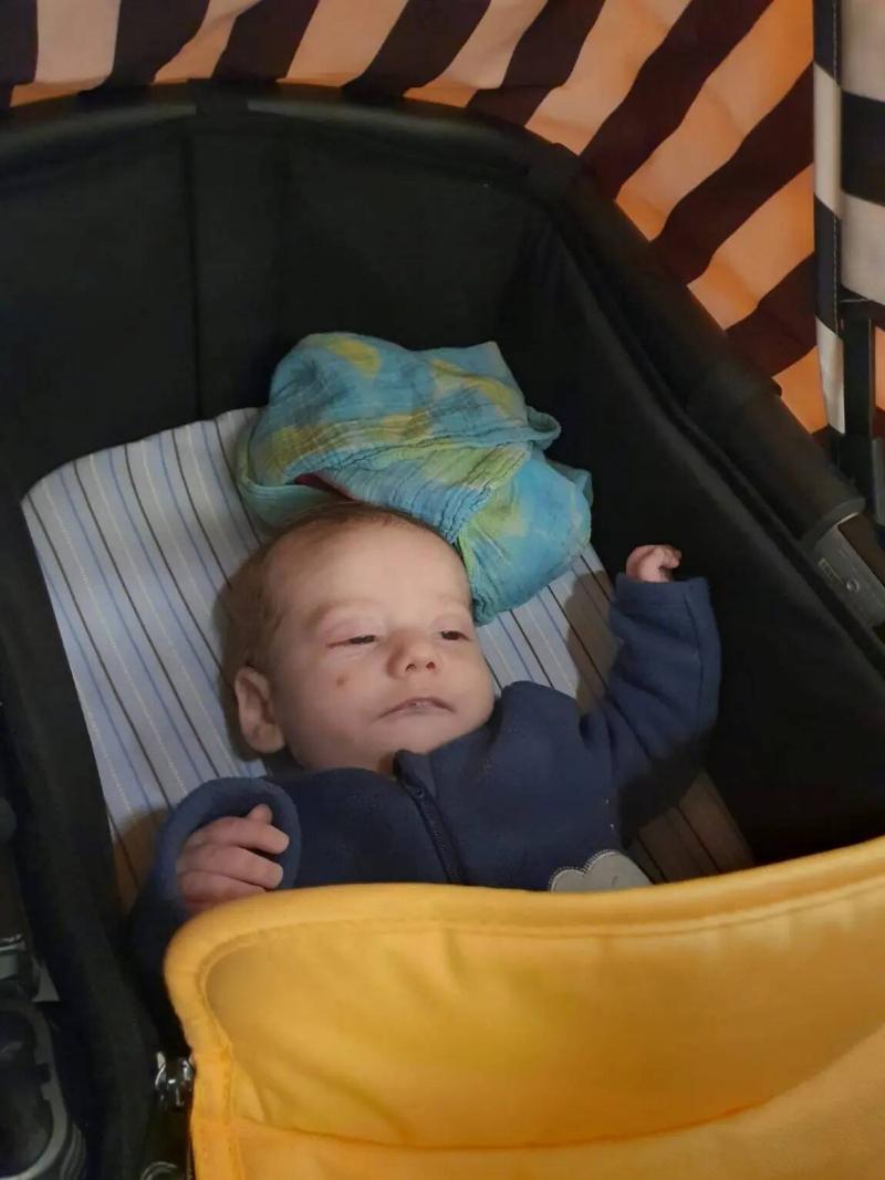 Baby Tomas in his stroller, eyes half open.