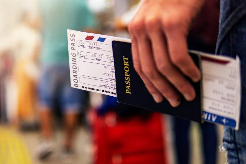 A close shot of someone holding a passport and boarding pass.