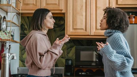 Two friends facing each other, arguing.