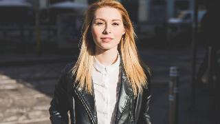 A young woman looking forward at the camera confidently.
