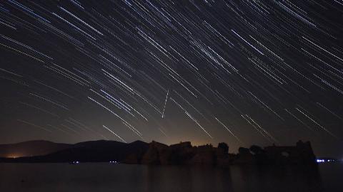 A timelapse photo of stars and meteors moving through the sky.
