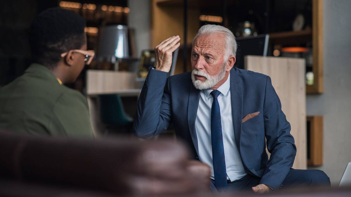 A man speaking angrily to a younger employee.