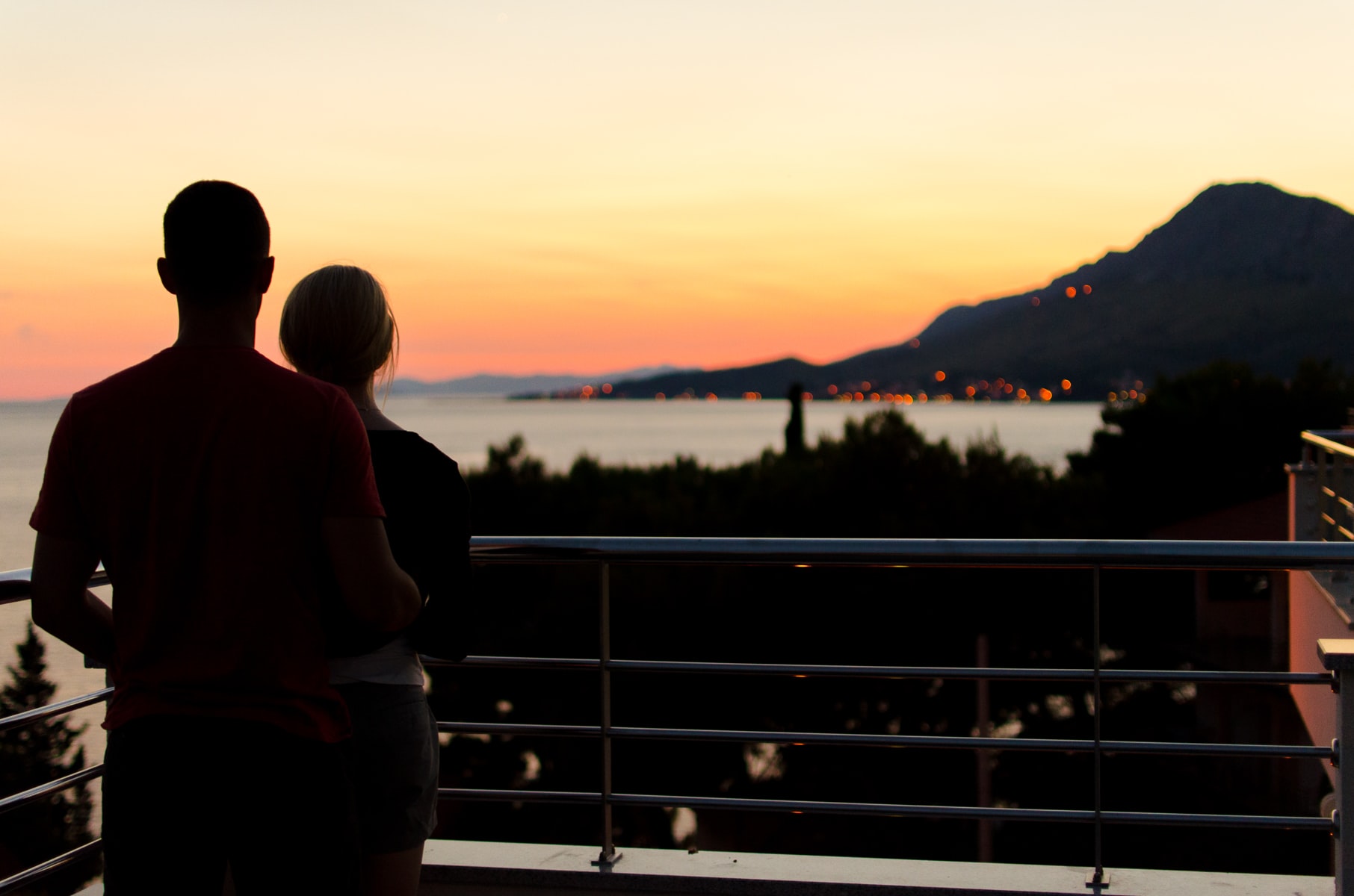 A couple standing on a balcony.