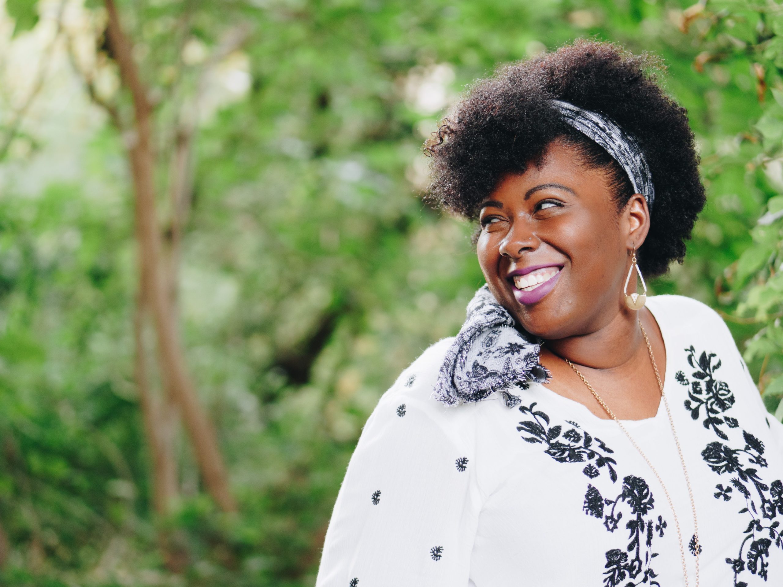 A woman smiling as she looks over her shoulder.