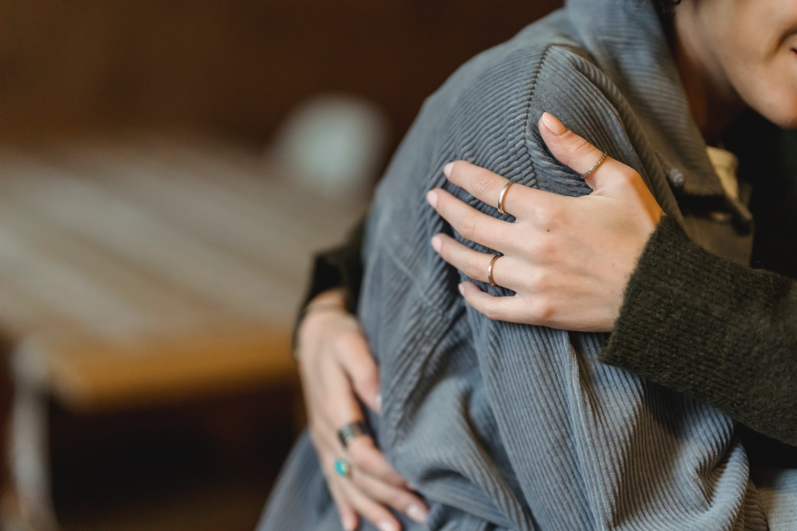 A side shot of two women hugging.