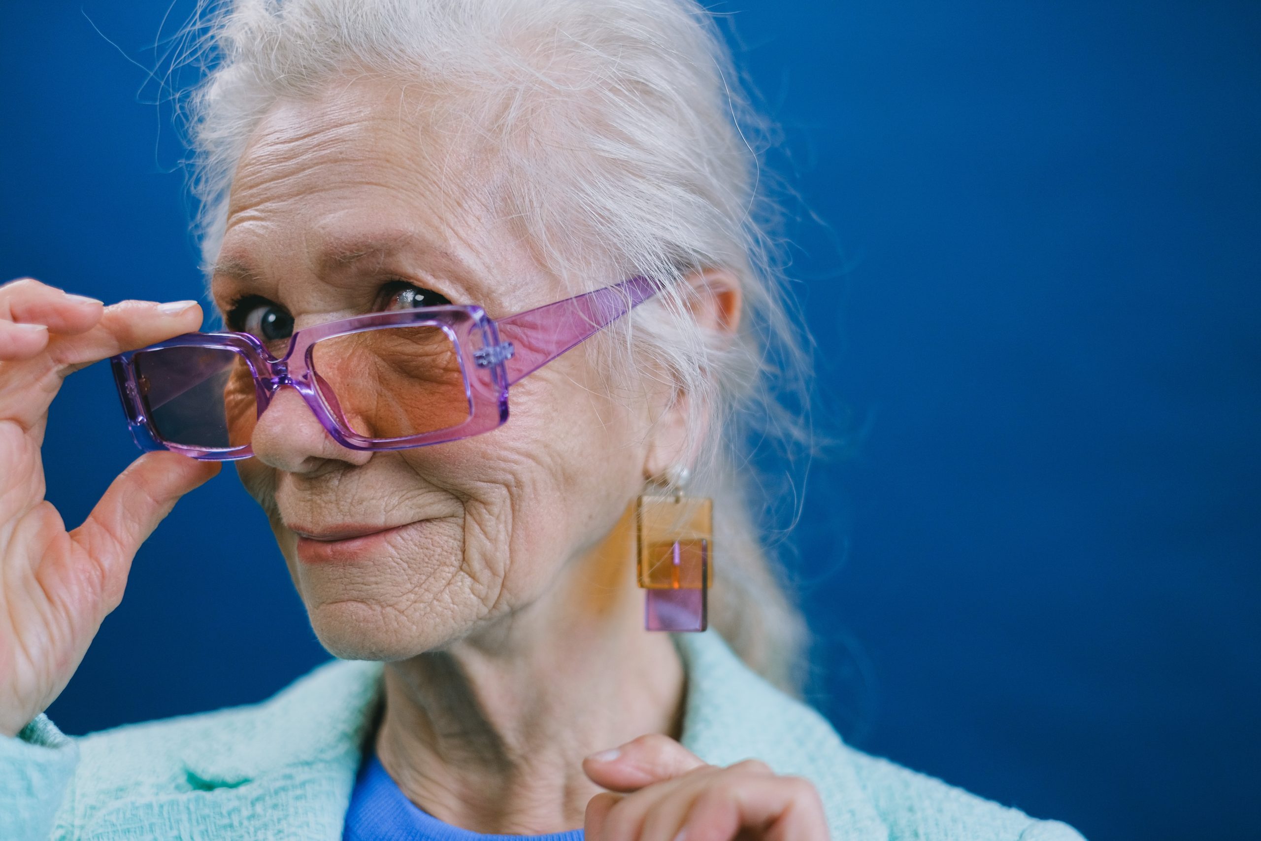An older woman in transparent, colorful, plastic jewelry and accessories.