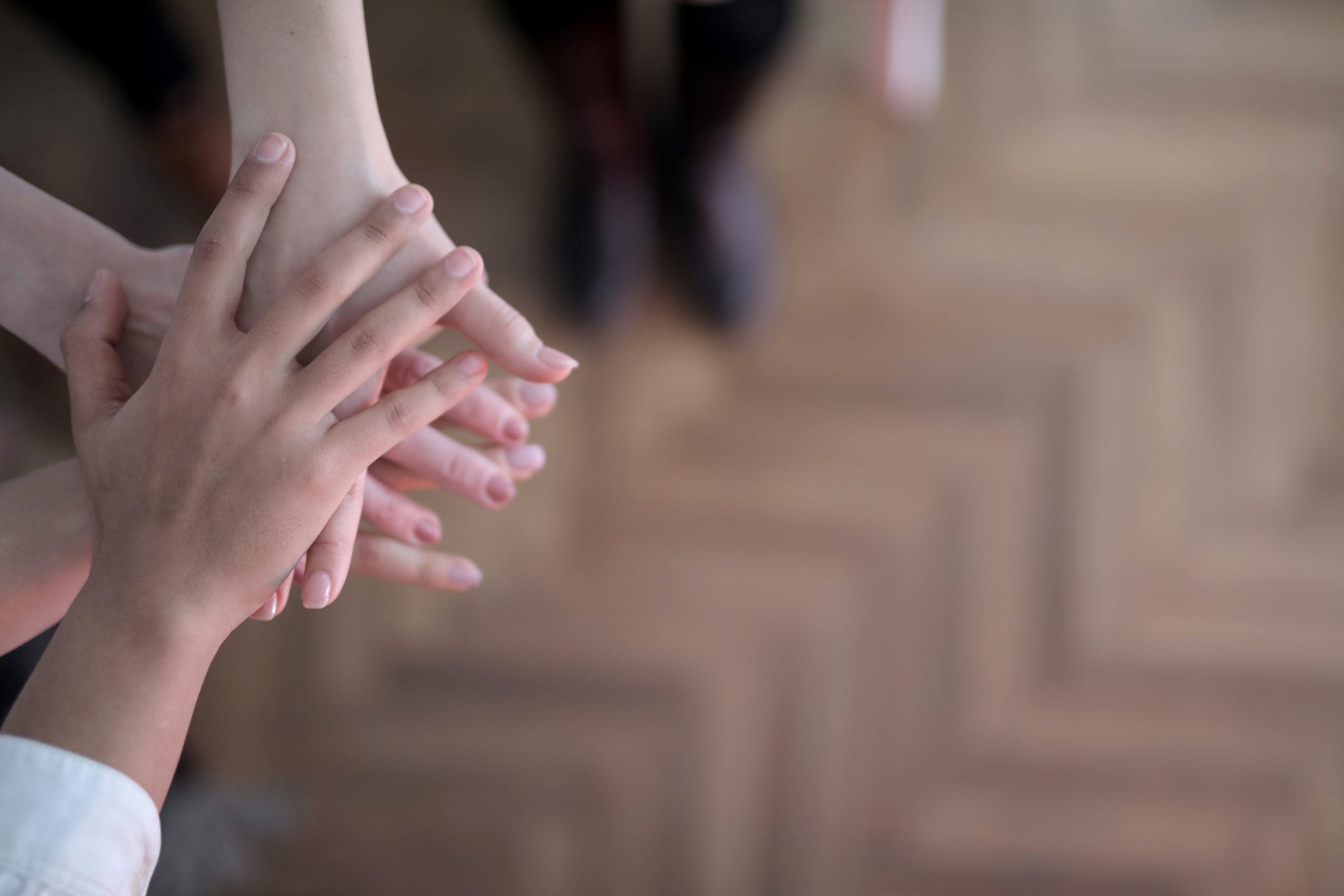 Three People putting their hands together.