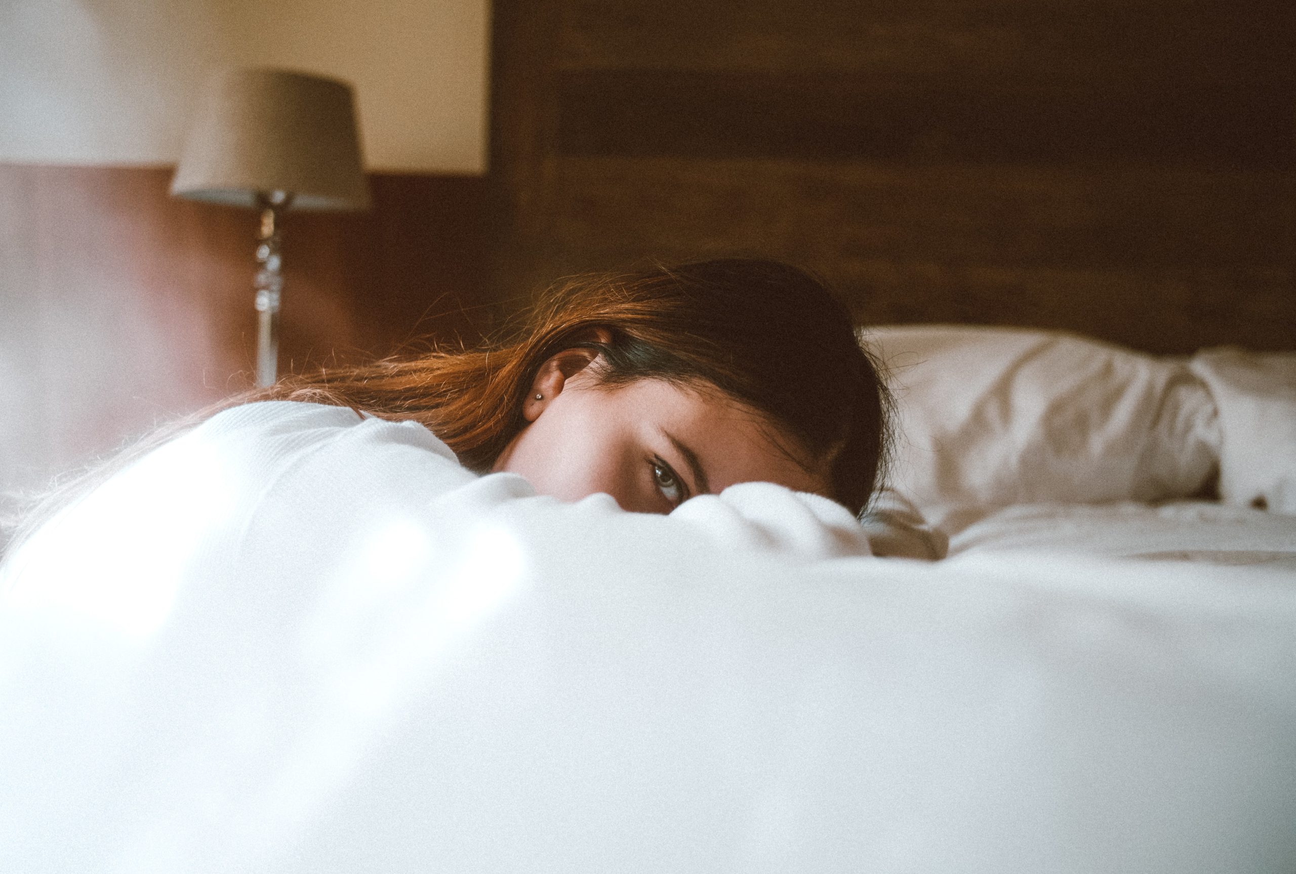 woman resting her face on a bed