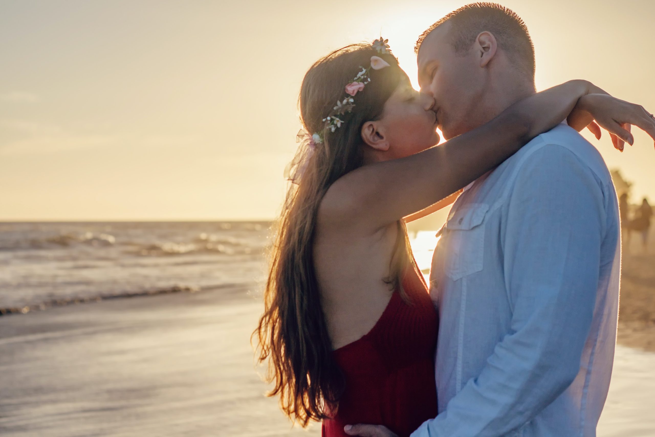 A couple kissing and embracing on the beach.