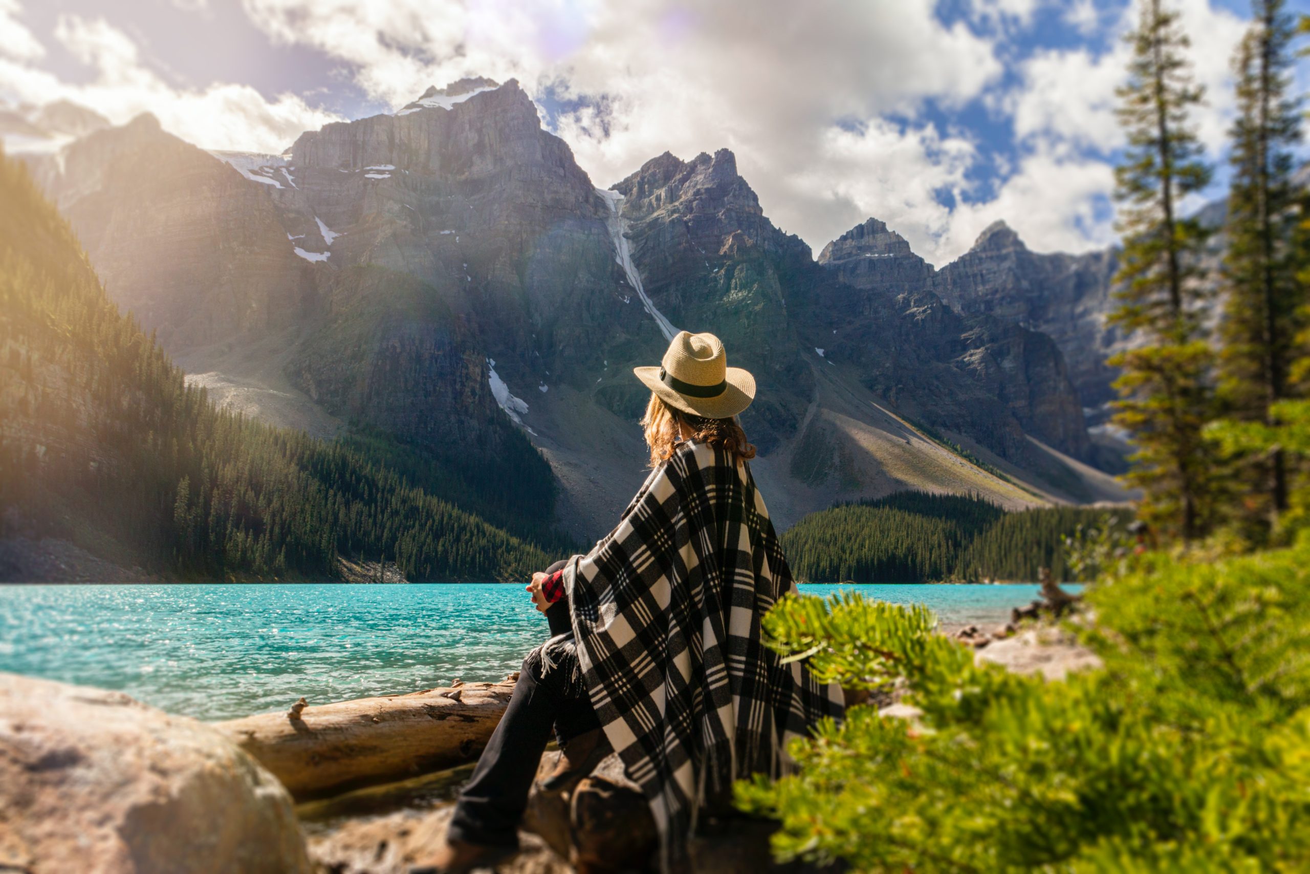 A woman sitting in front of a mountain range.