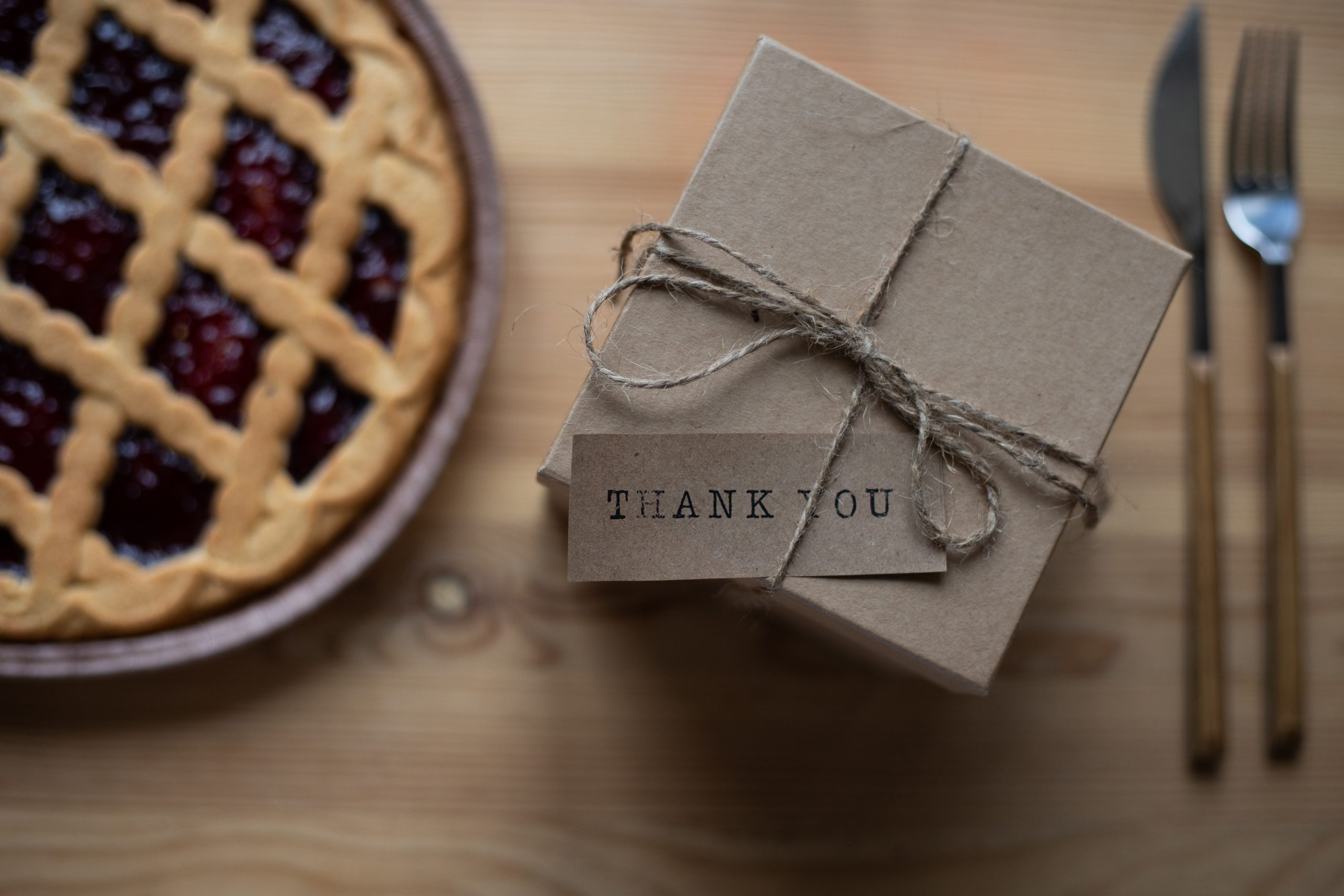 A small box wrapped in plain paper with a  tag that says 'thank you'.