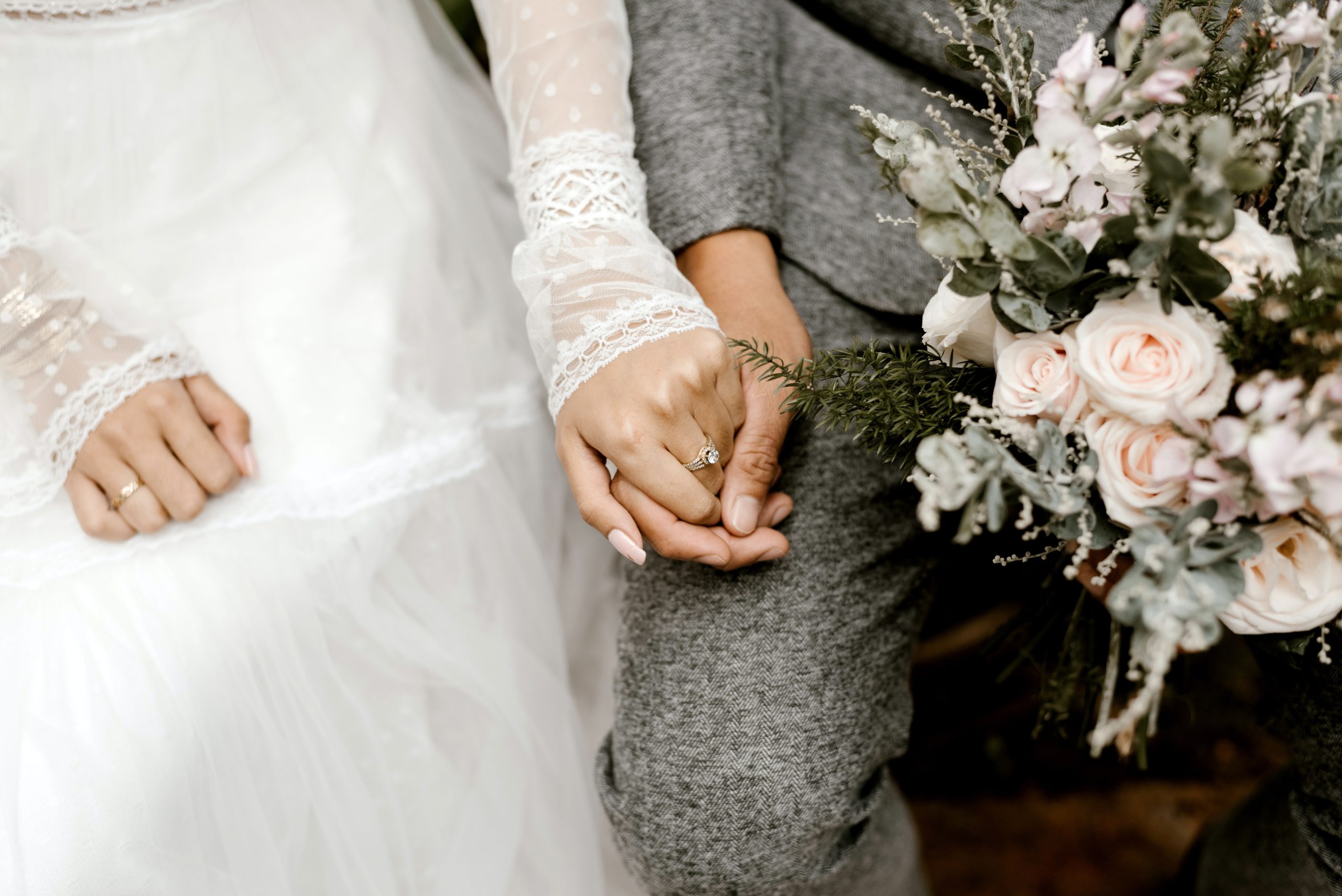 A married couple holding hands while sitting down.