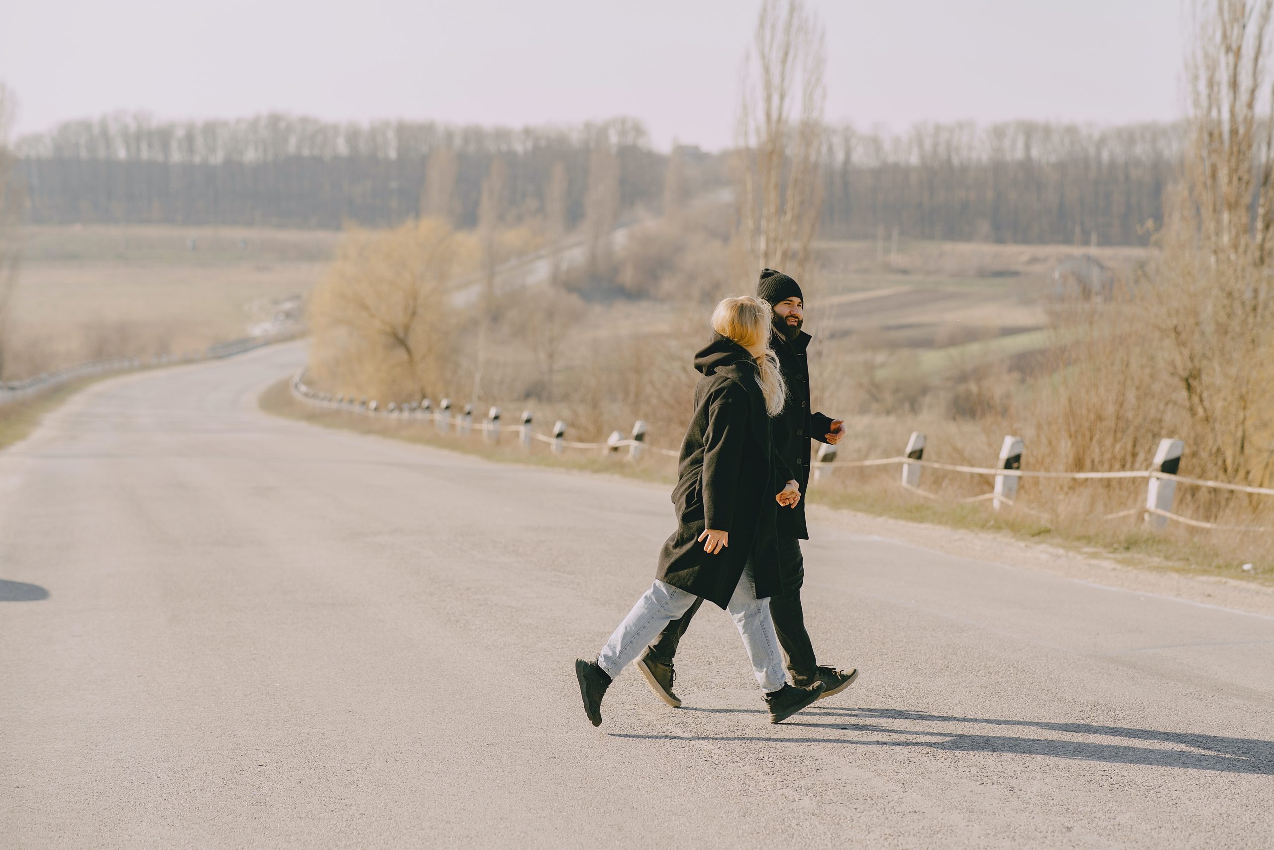 A couple walking across a road.