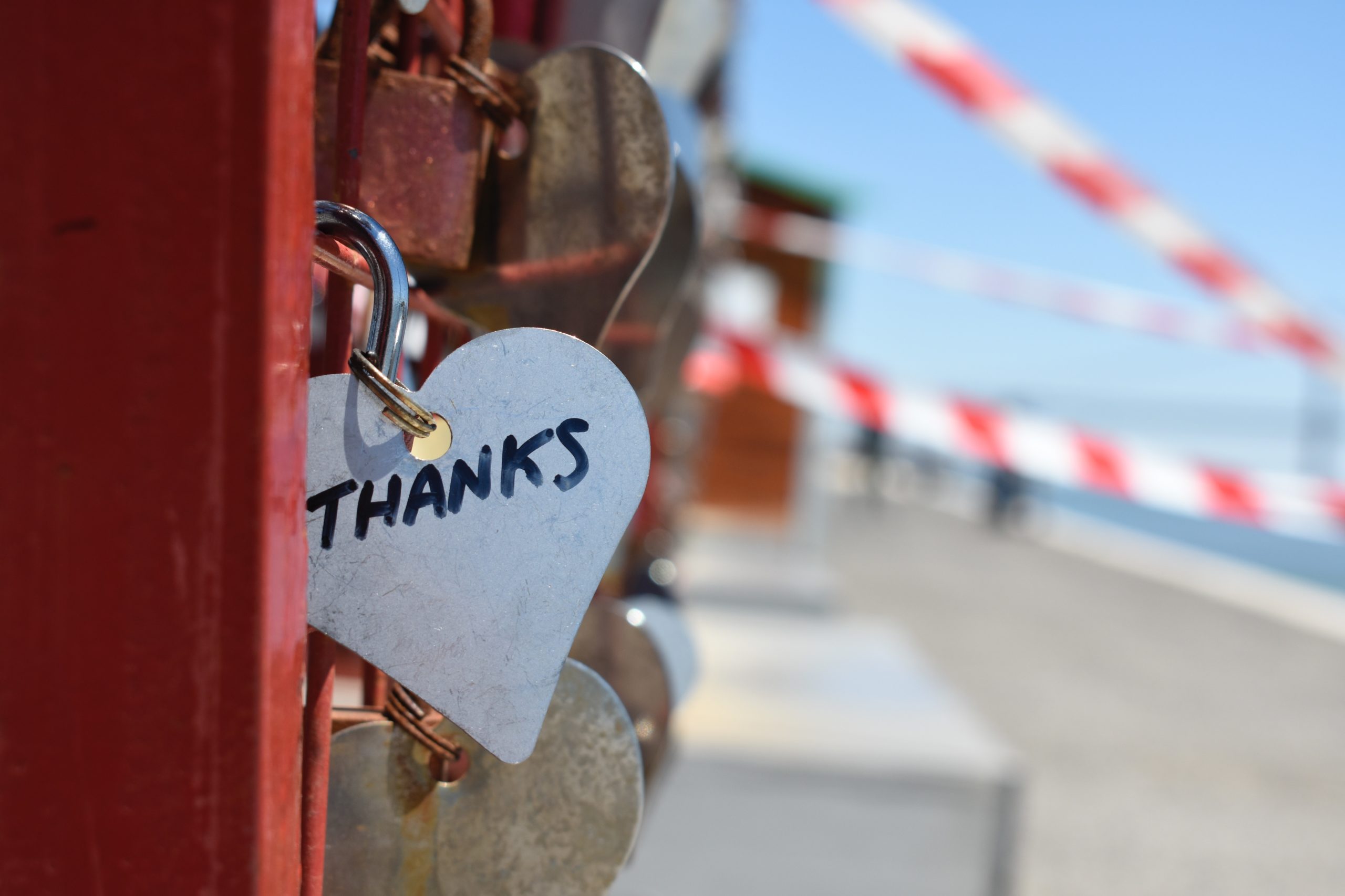 A heart tag with the word 'thanks' written on it that's attached to a padlock.
