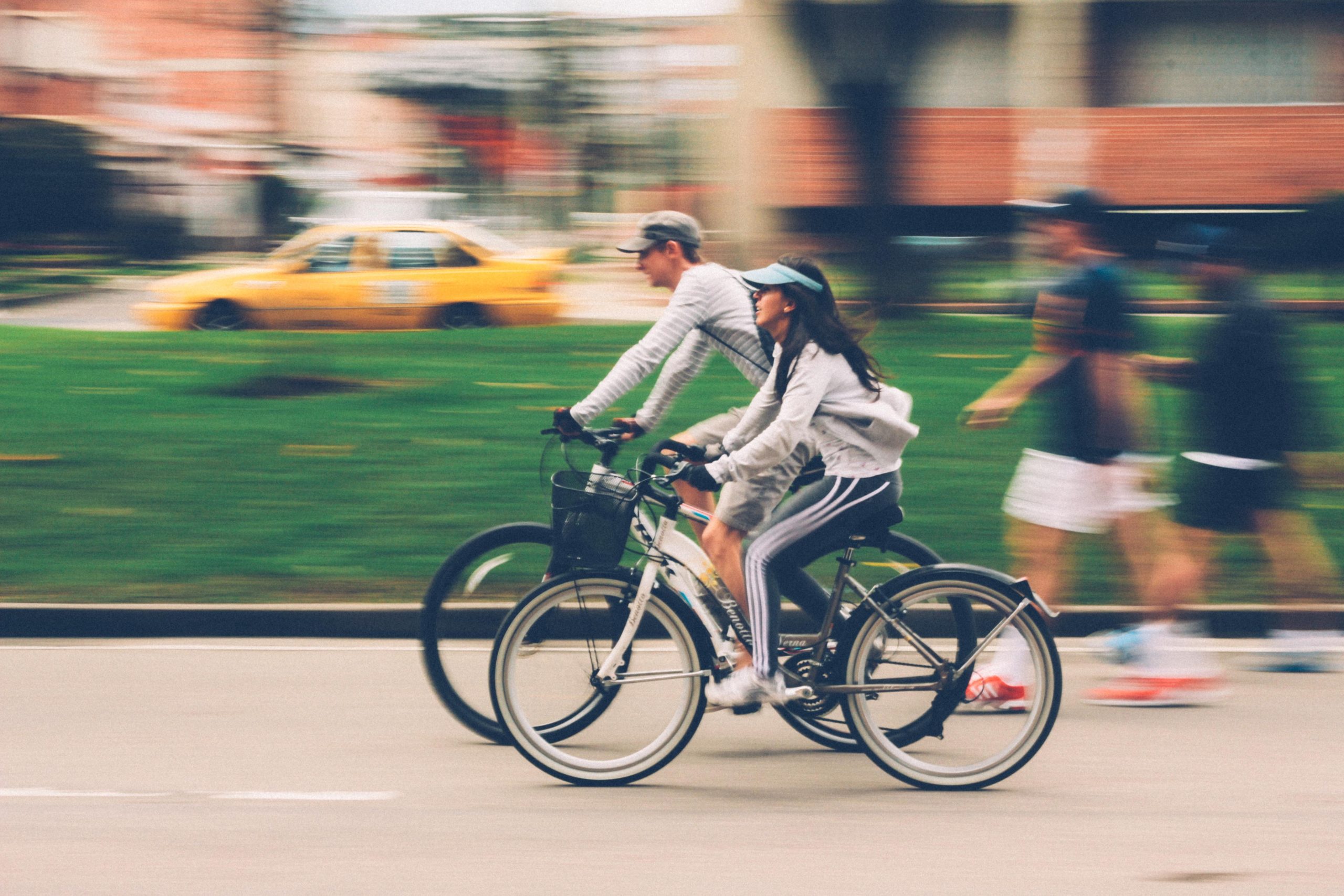 A couple each riding a bike next to one another.
