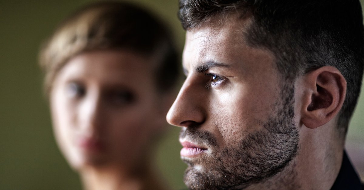 man's profile with woman blurred in the background