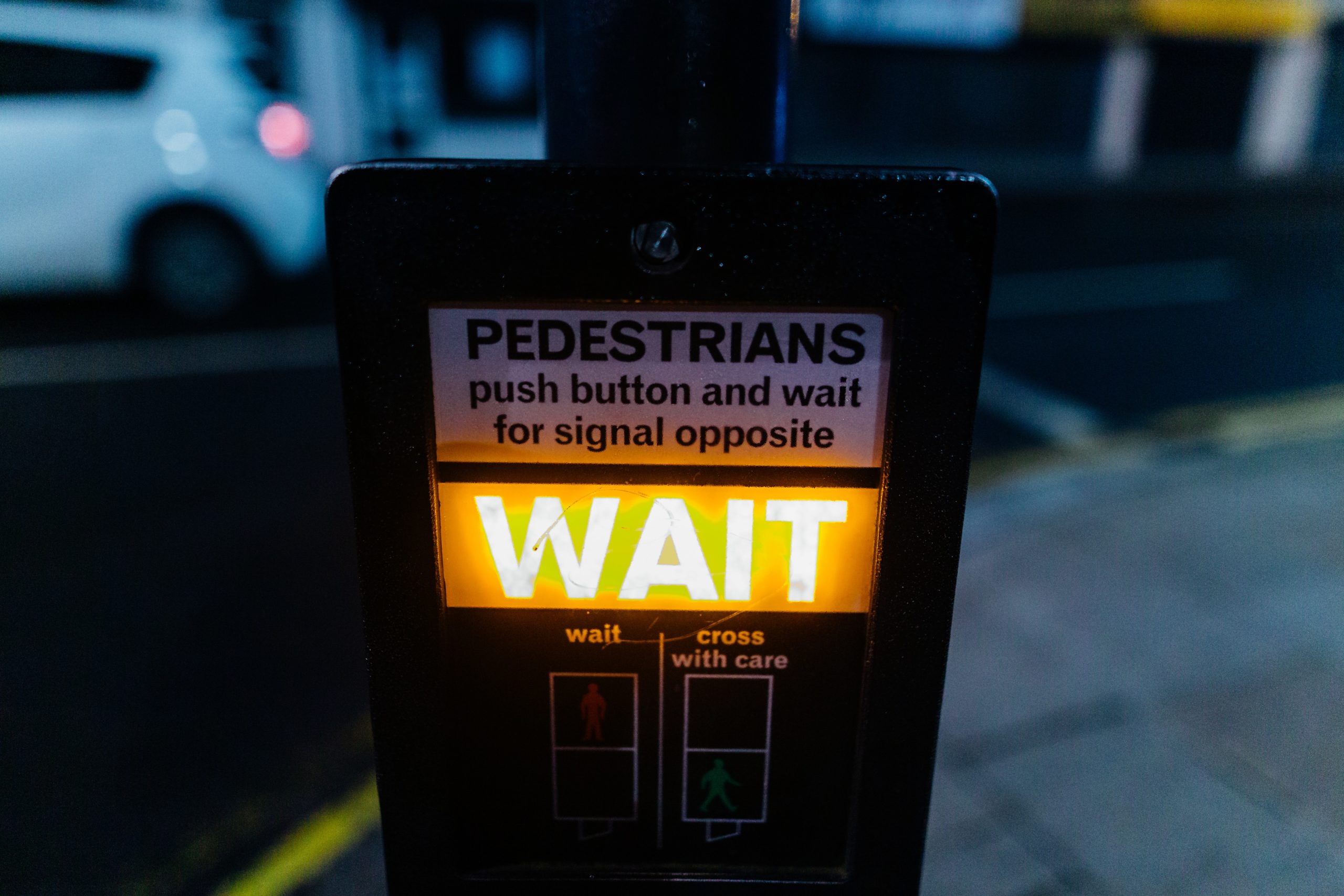 A 'pedestrian wait' sign lit up yellow.