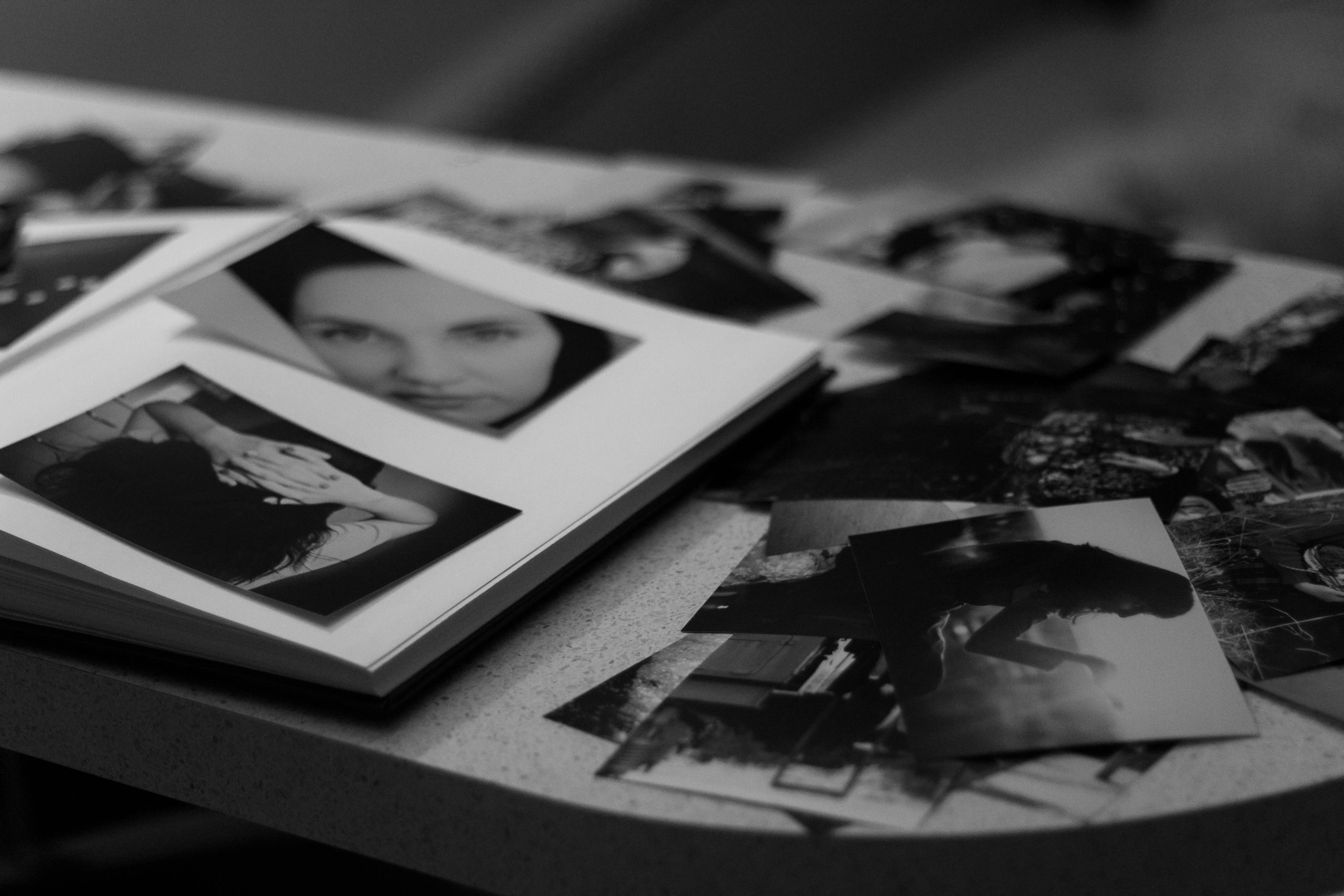 A greyscale image of a table covered in photos.