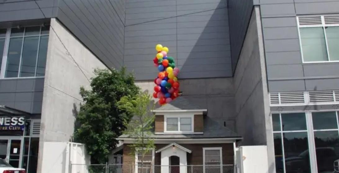 house between building with balloons on top