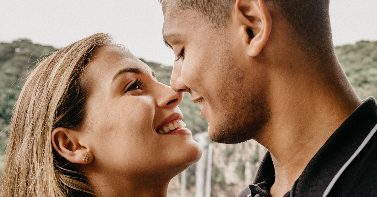 couple almost kiss smiling at each other