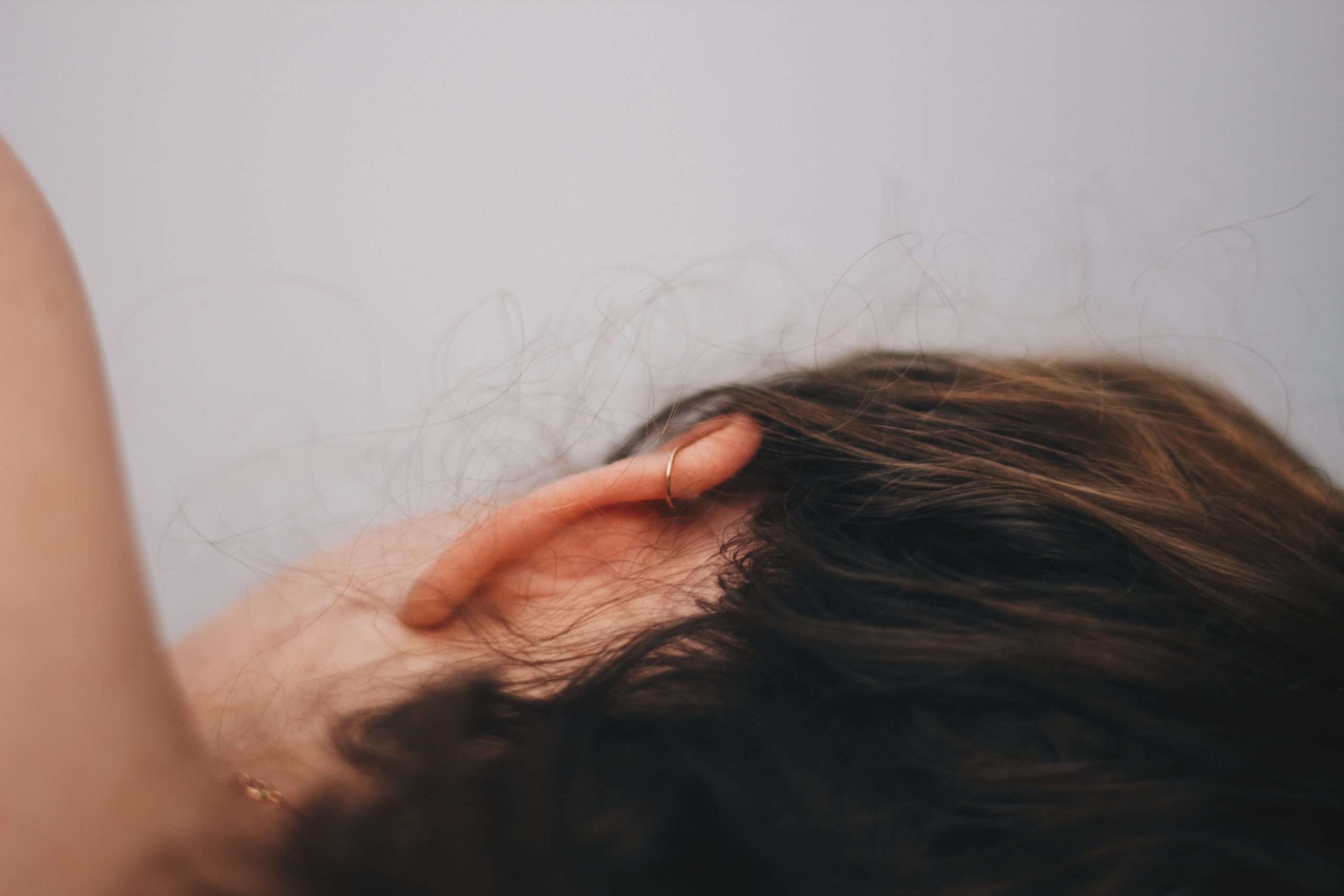 close up of woman laying on her side ear