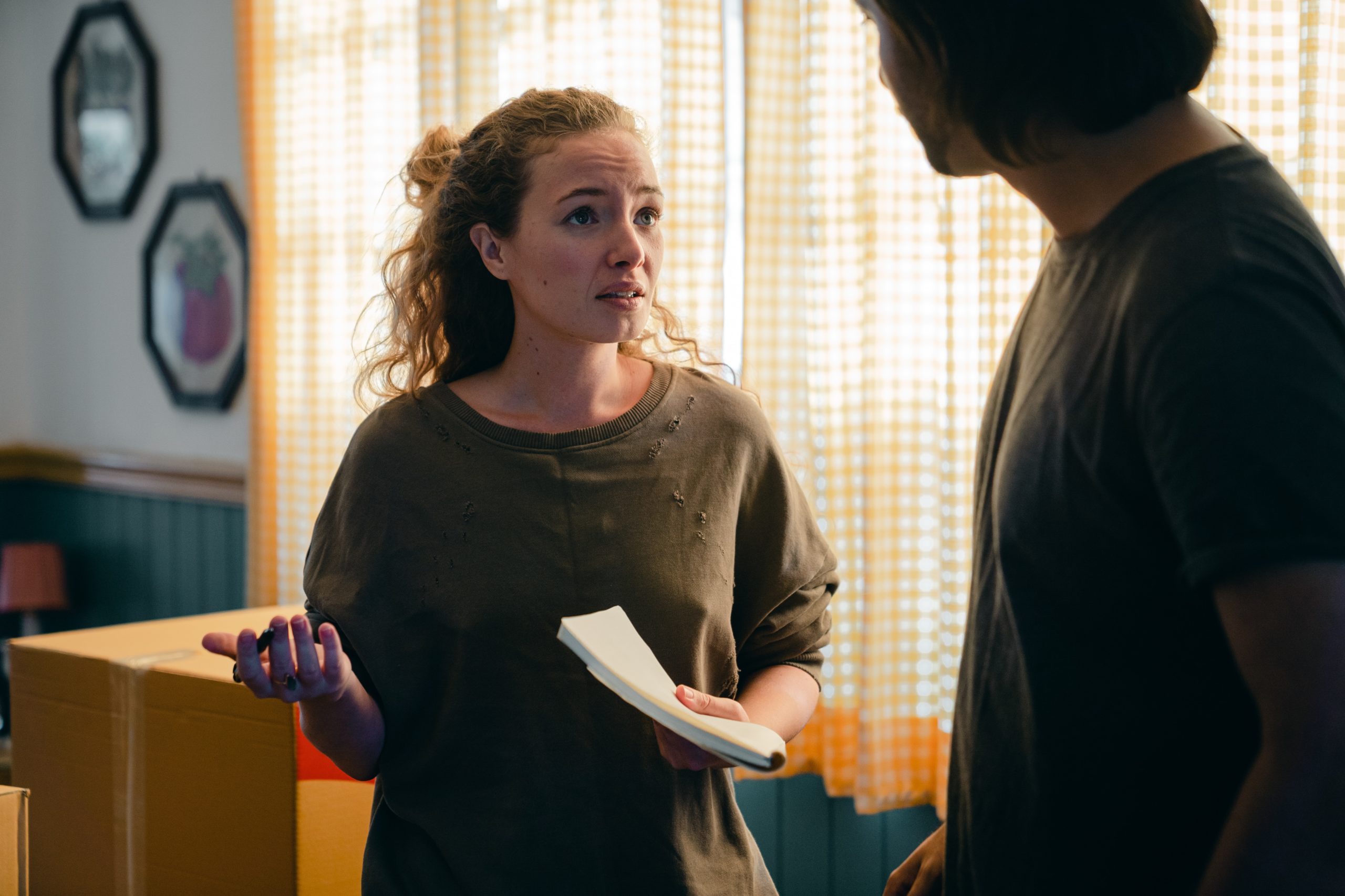 woman holding notebook looking confused at male partner