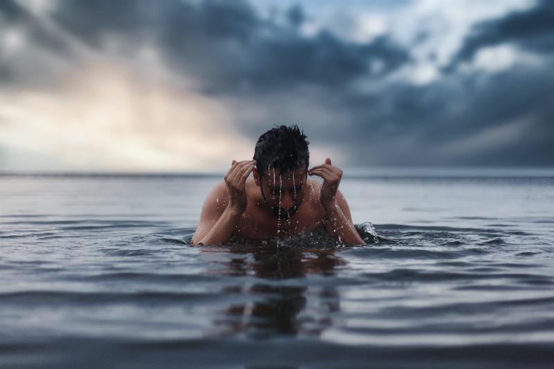 man taking a dip in the ocean