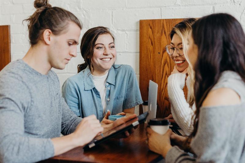 men and three women talk at coffeeshop