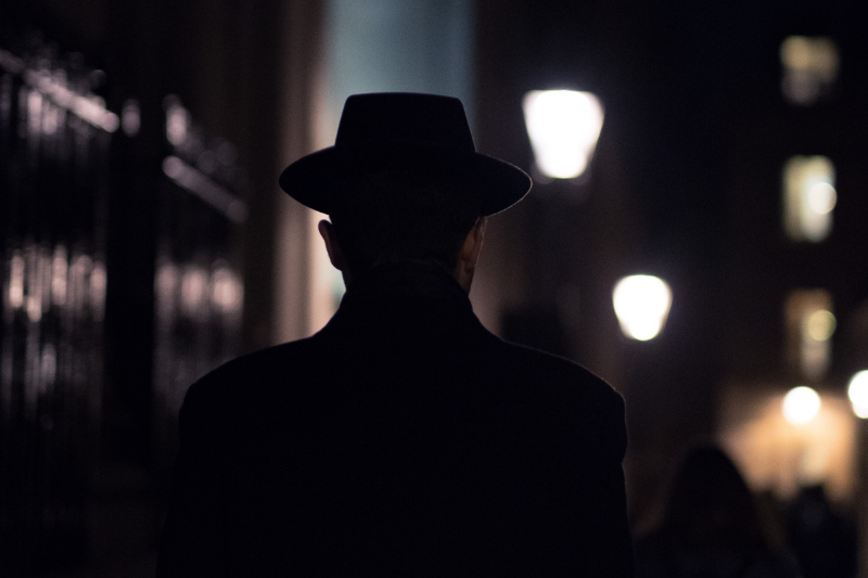 man in fedora walking at night