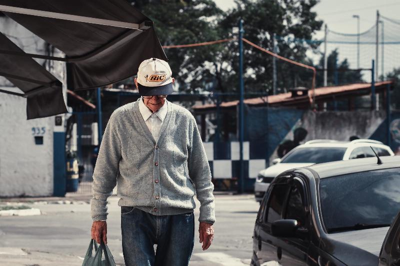 old man walking with cap on