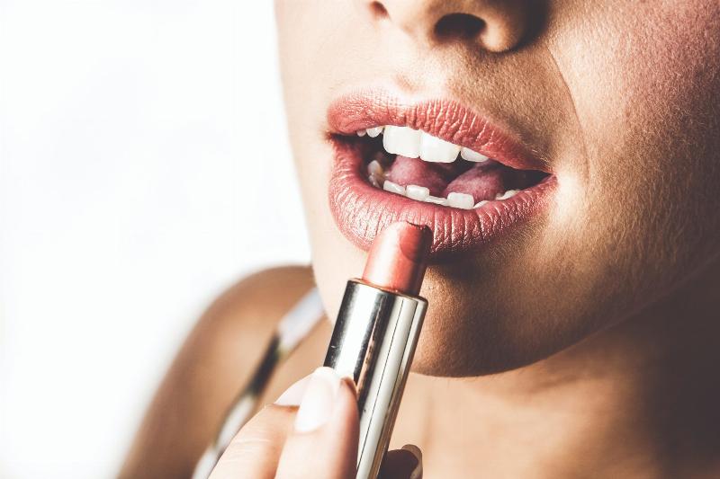woman applies lipstick